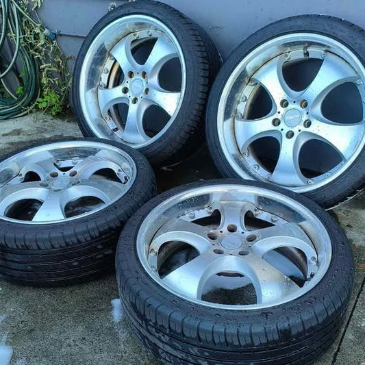 Set of alloy wheels and tires on a concrete surface